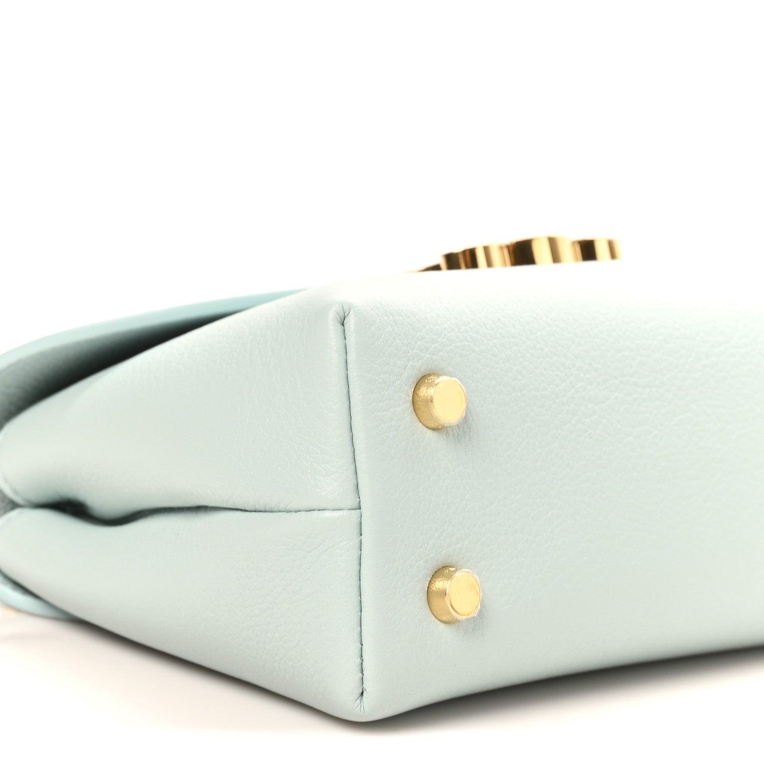 Light blue leather handbag with two gold snap buttons at the side
