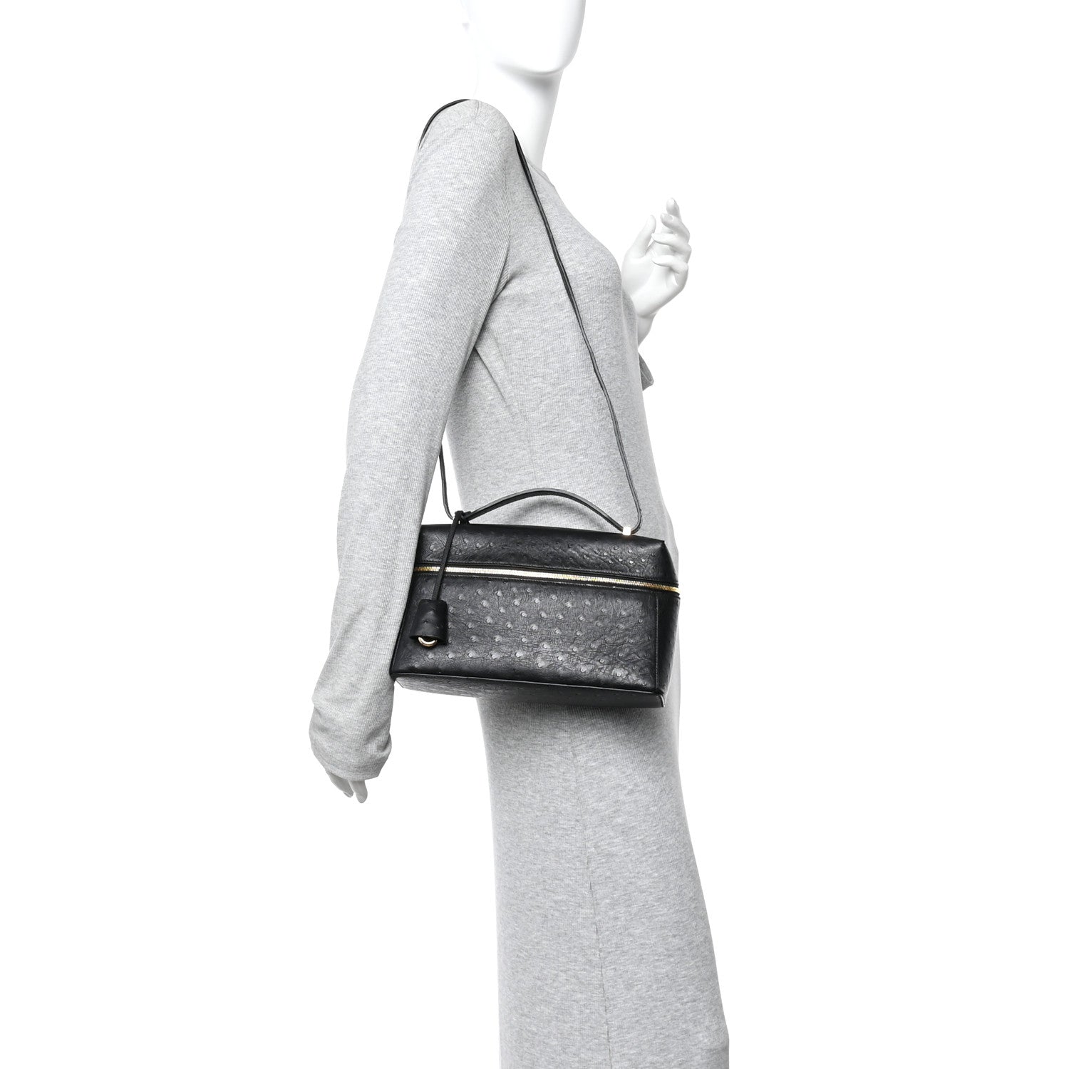 Black ostrich leather crossbody mini bag with shoulder strap and front zip closure on person