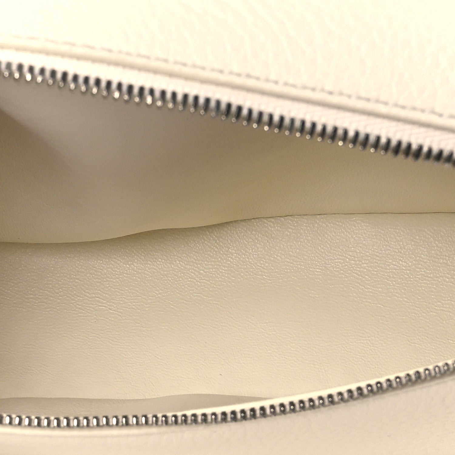 Pouch interior seam and zipper teeth along the top opening