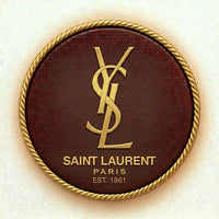 Saint Laurent logo on a round brown leather patch with gold border