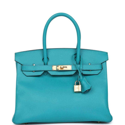 Elegant turquoise leather handbag with gold hardware and a timeless, sophisticated design.