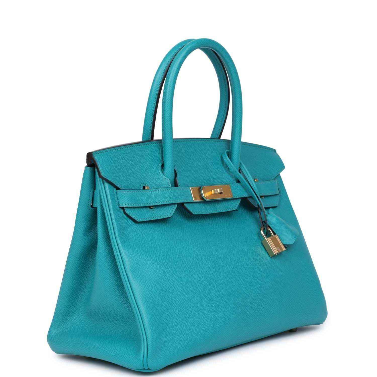Elegant turquoise leather handbag with gold hardware, timeless and sophisticated design.