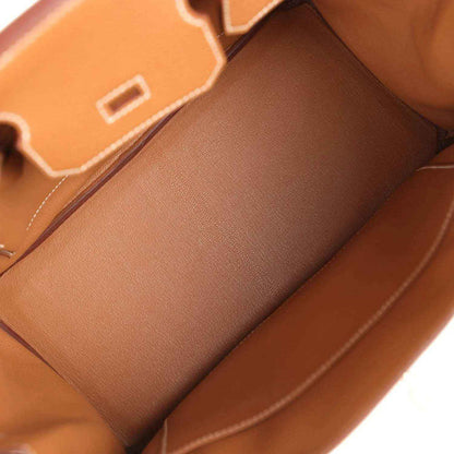 Spacious interior of a timeless tan leather handbag with elegant, refined stitching.