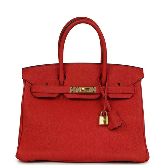 Timeless, elegant red leather handbag with gold hardware and sophisticated detailing.