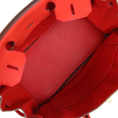 Interior of a sophisticated red leather handbag with elegant, timeless detailing.