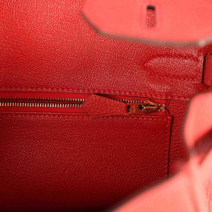 Elegant red leather handbag interior with gold zipper, showcasing timeless sophistication.