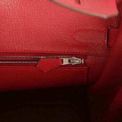 Elegant red leather handbag interior with silver zipper and refined stitching, timeless style