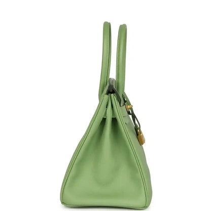 Elegant sage green leather handbag with gold accents, timeless and sophisticated design