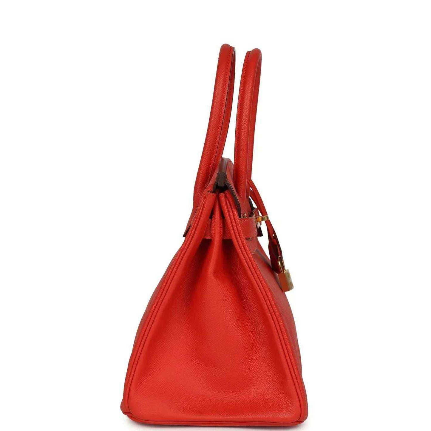 Elegant red leather handbag with gold accents, featuring a timeless and sophisticated silhouette.