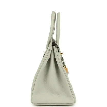 Elegant light grey leather handbag with gold accents and a timeless, sophisticated silhouette.