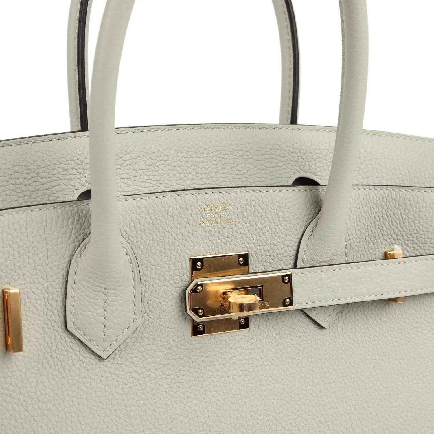 Elegant light grey leather handbag with gold hardware and a timeless, sophisticated design