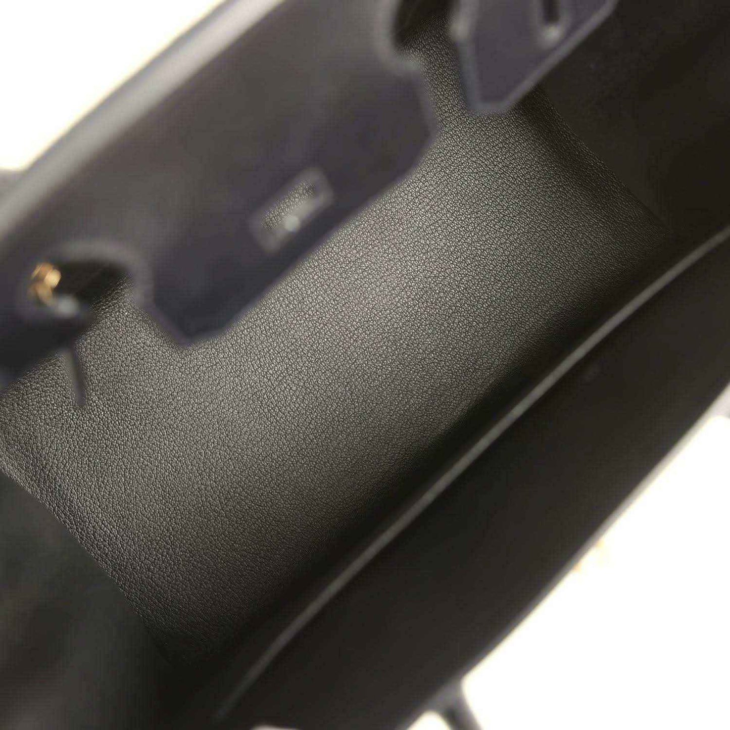 Birkin handbag close-up of black leather texture near edge stitching and hardware