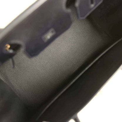 Birkin handbag close-up of black leather texture near edge stitching and hardware