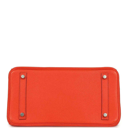 Elegant orange leather handbag base with silver-tone feet, showcasing timeless craftsmanship.
