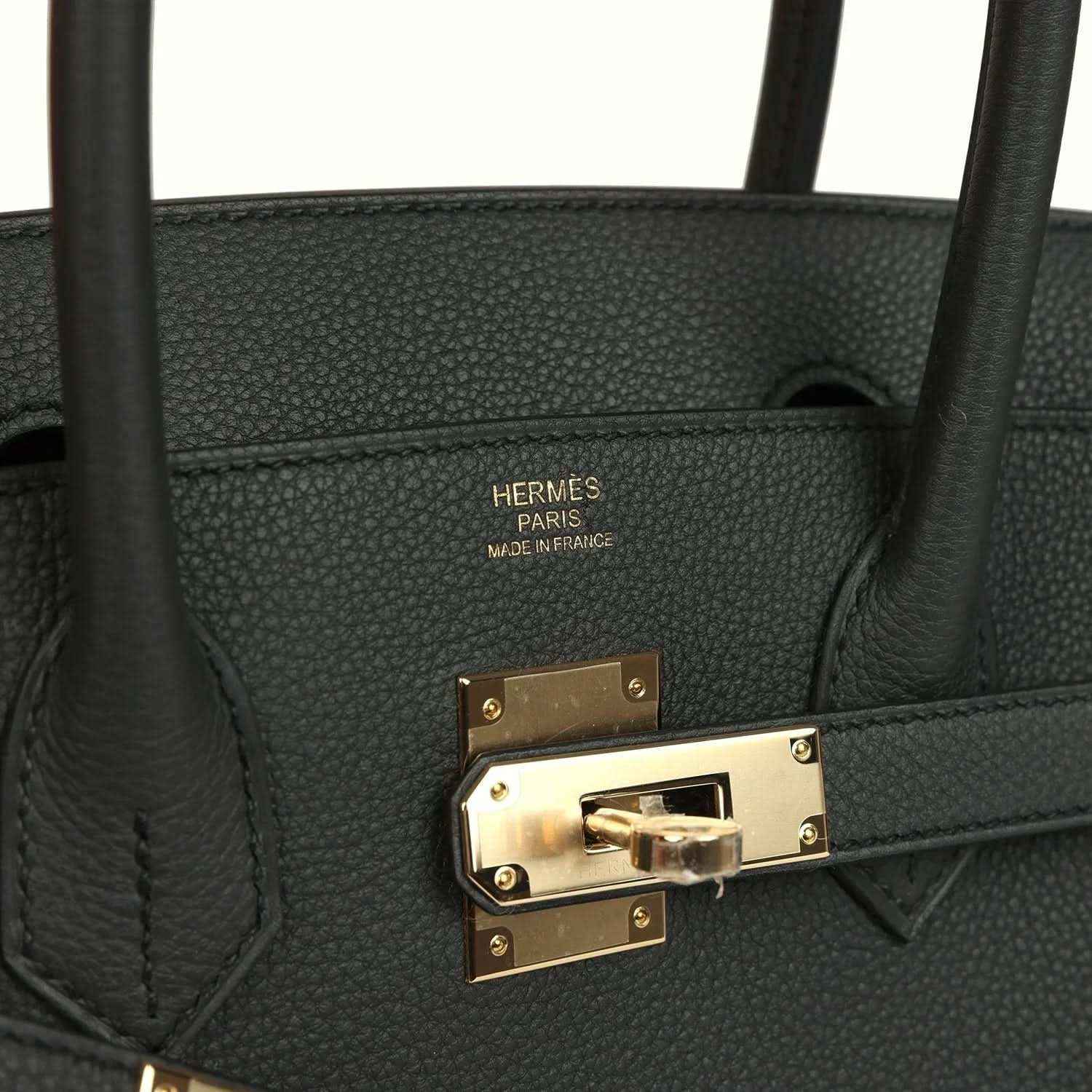 Elegant black leather handbag with gold hardware and refined, timeless design details.