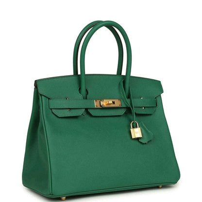 Green leather handbag with top handles, front flap lock, and gold-tone hardware