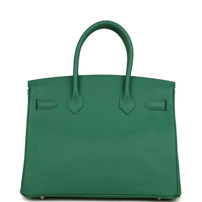 Green leather handbag with structured silhouette, top handles, and front flap panels