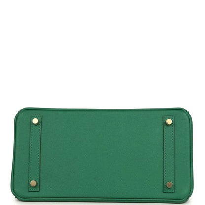 Green leather handbag with rectangular shape, top handles, and corner hardware accents