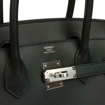 Black leather handbag interior with stamped label and metal closure bar