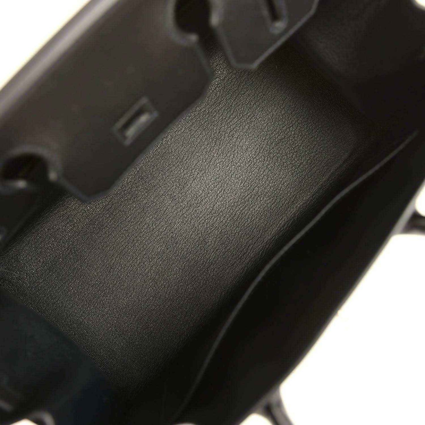 Black leather handbag close-up of textured panel and visible seam stitching
