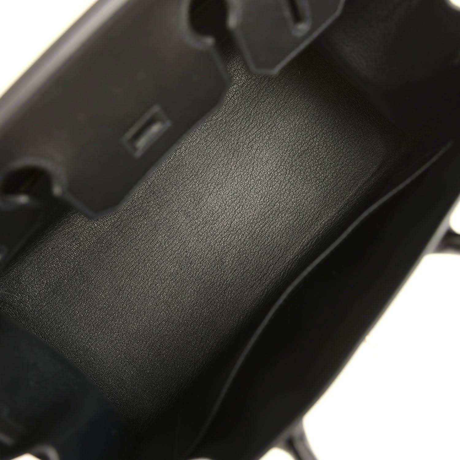 Black leather handbag close-up of textured panel and visible seam stitching