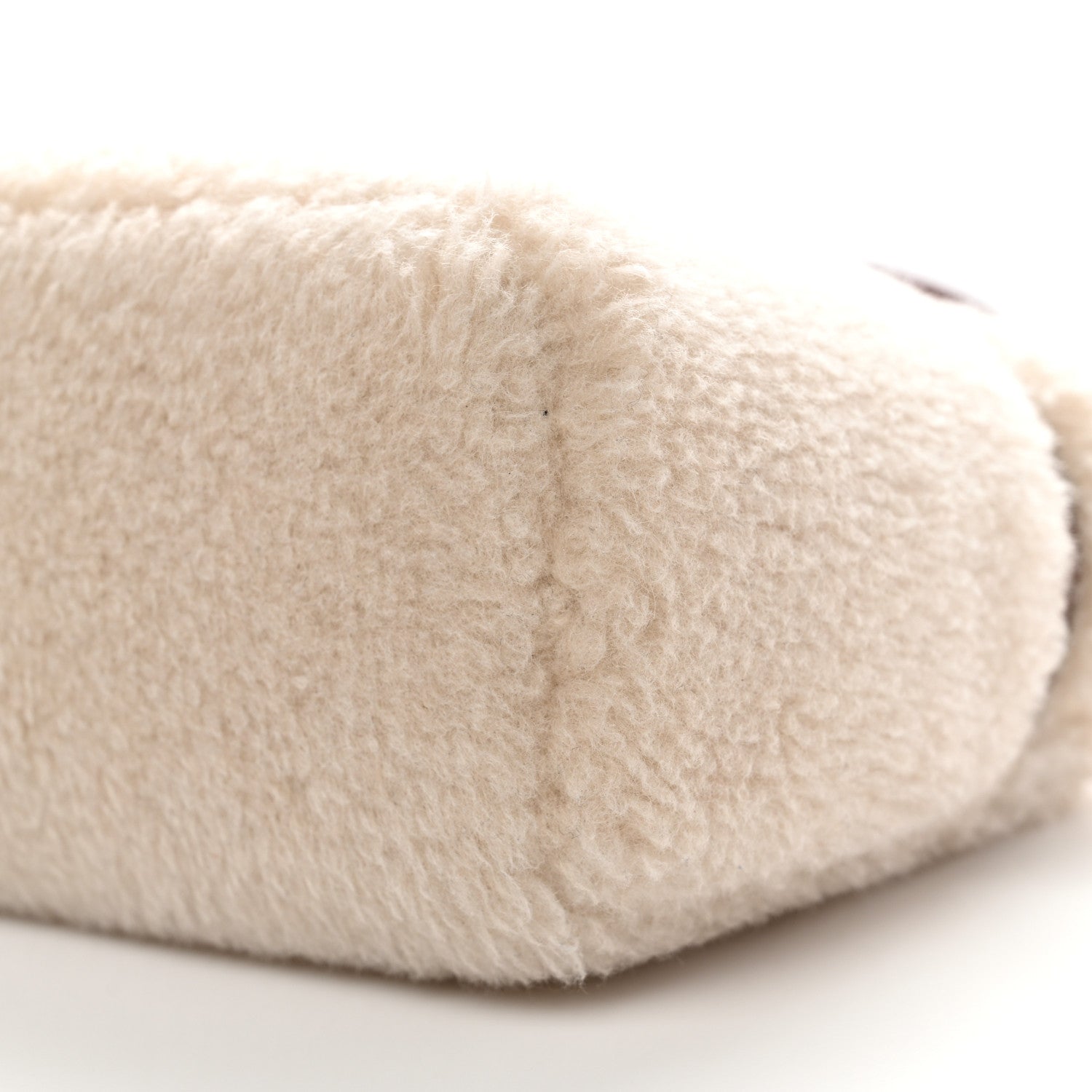 Cream faux-fur pouch close-up of textured exterior fabric
