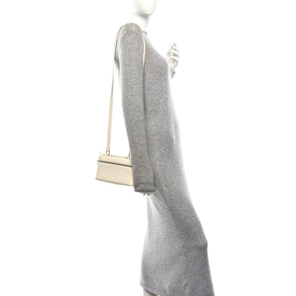 Whisper white calfskin pouch shown from side with slim crossbody strap