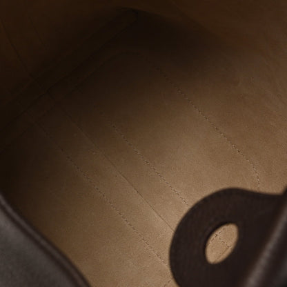 Dark brown leather interior closeup with stitching and a partial circular hole