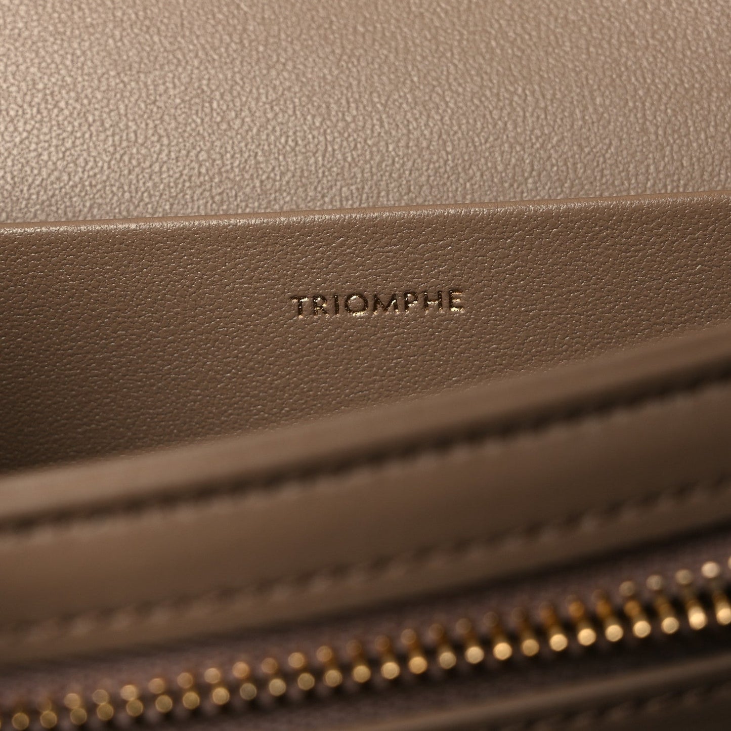Triomphe embossed on beige leather