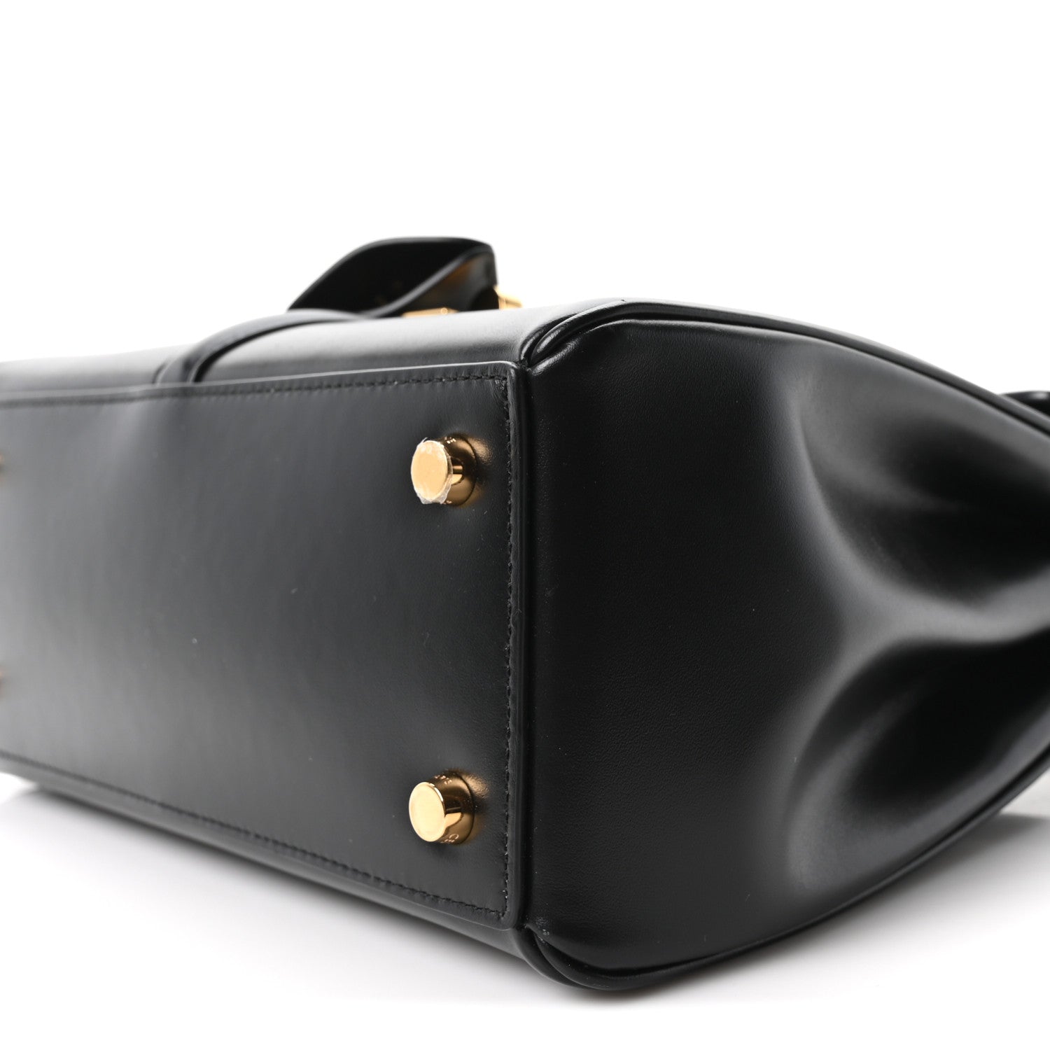 Celine mini bag close-up in black leather with round gold studs on side panel