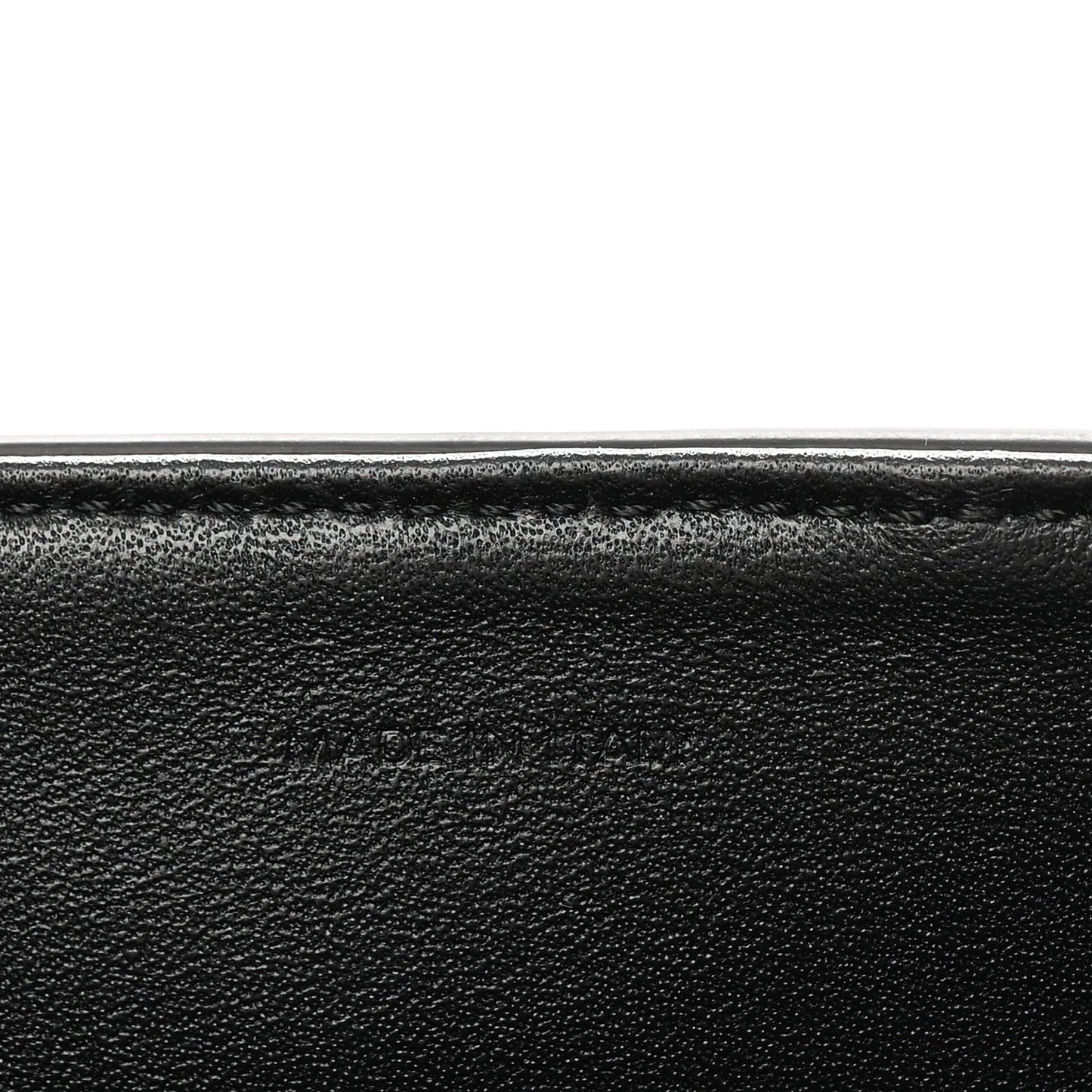 Black grained leather close-up with smooth edge seam detail