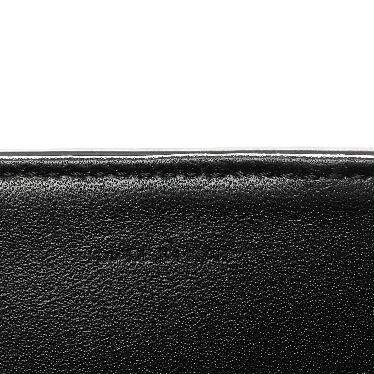 Black grained leather close-up with smooth edge seam detail