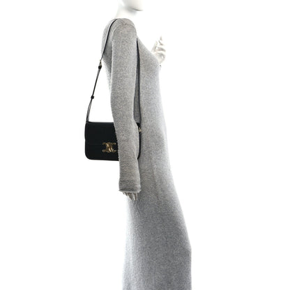 Shiny calfskin shoulder bag in black worn crossbody with gold hardware on flap