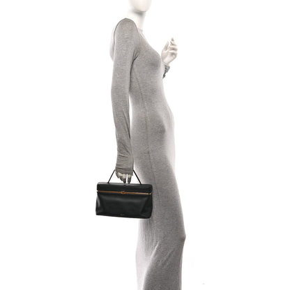 Celine black rectangle bag worn by model, with top handle and gold-tone clasp
