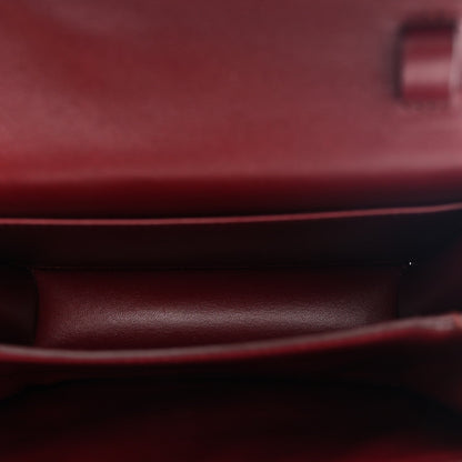 Burgundy leather interior lining view under the front flap of a structured bag.