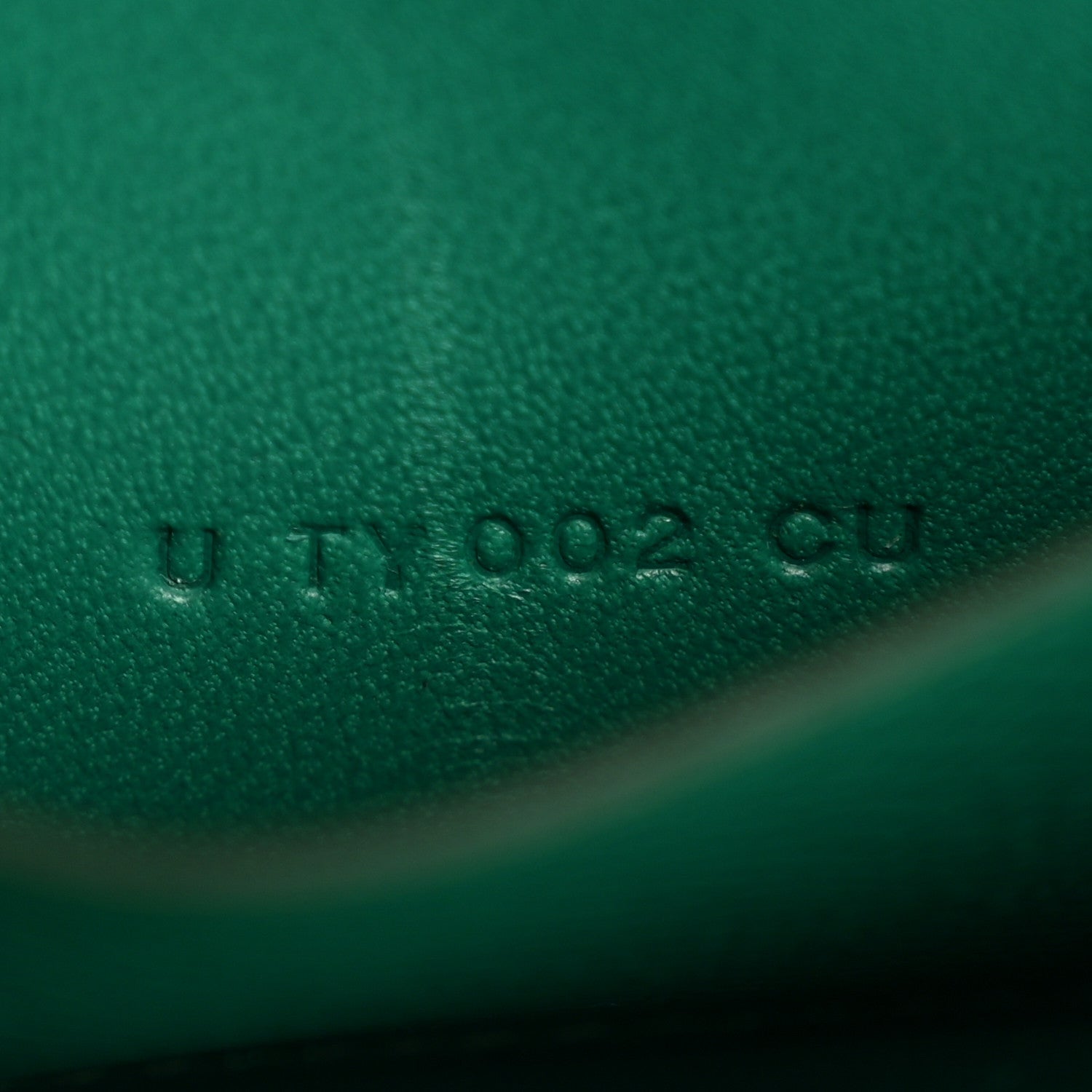 Green leather emboss mark with small printed characters