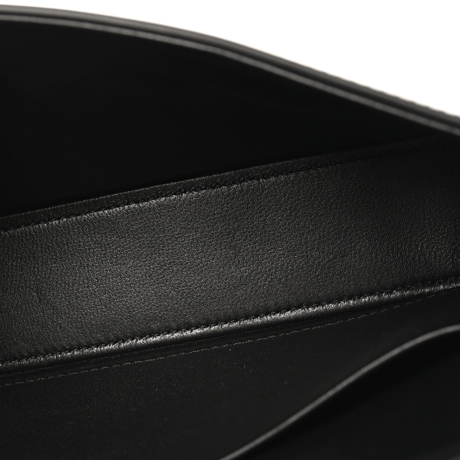 Black shiny calfskin leather close-up with stitched edge and smooth glossy finish