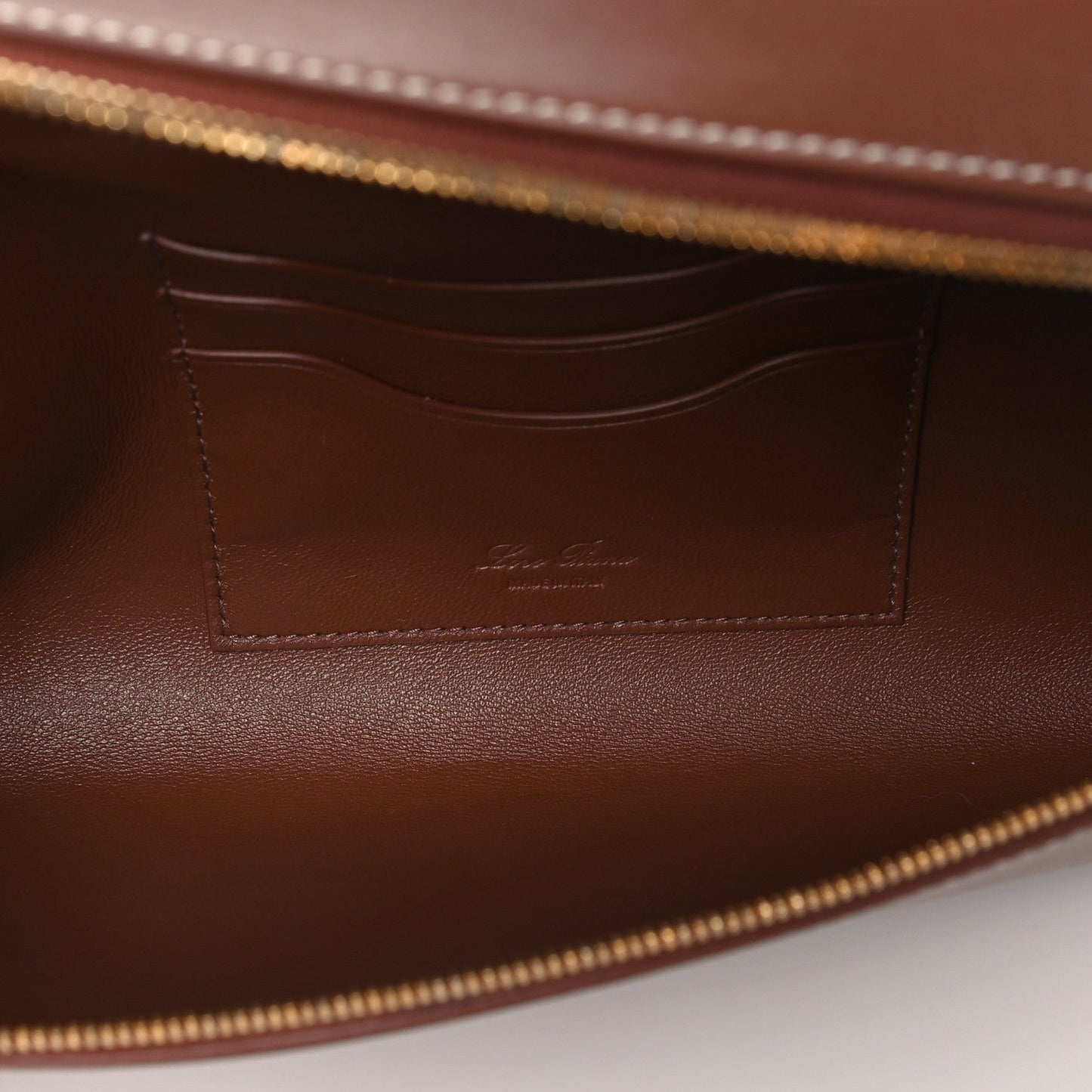 Loro Piana smooth calfskin clutch interior with stitched pocket and gold zipper trim