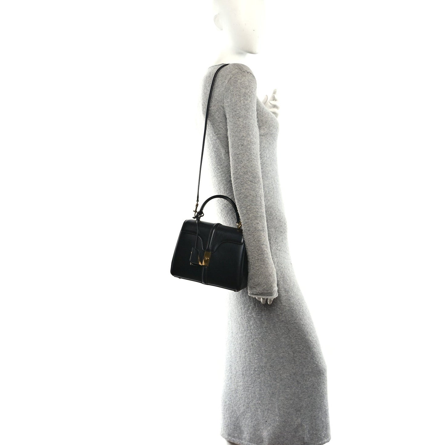 Celine mini crossbody bag in black leather with gold hardware, worn over a sleeve