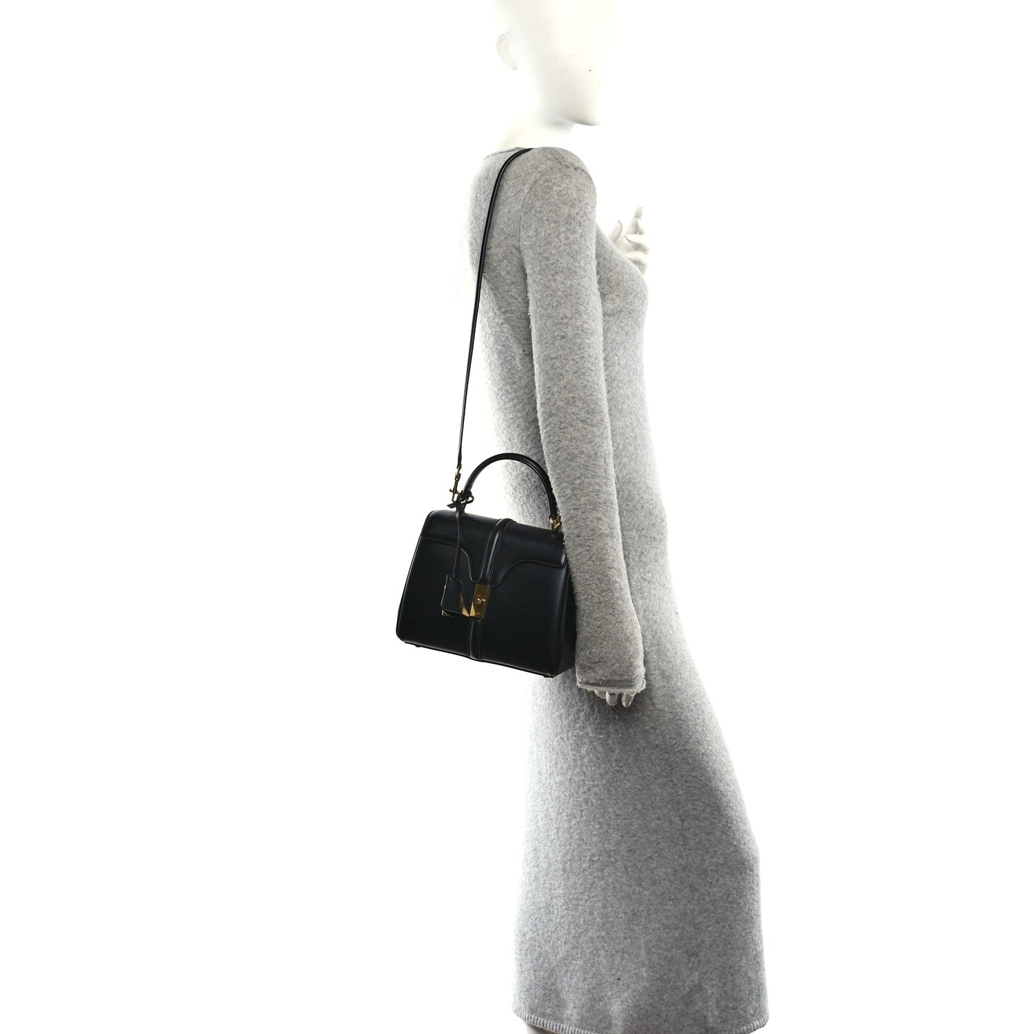 Celine mini crossbody bag in black leather with gold hardware, worn over a sleeve