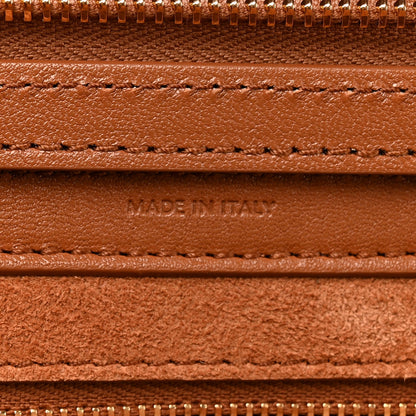 Tan leather handbag lining close-up with stitching and embossed label.