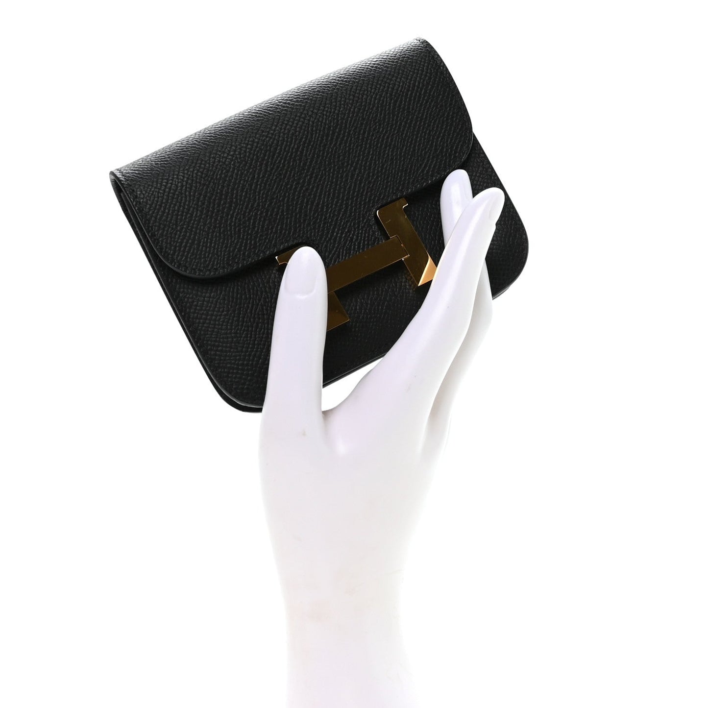 Hermes Constance slim wallet in black with gold H clasp, flap and angled side view