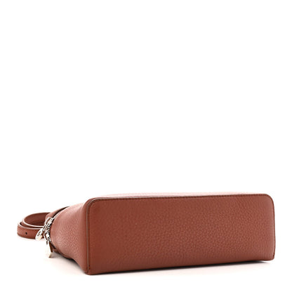 Grained calfskin pouch with rounded base and top zip, worn with leather strap