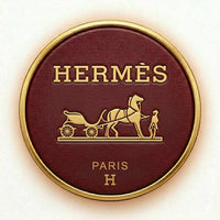Hermes logo on a round, maroon background with gold border