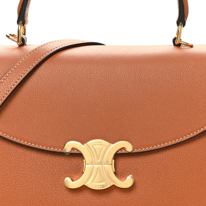Tan leather handbag flap with gold C-logo clasp and contrast stitching