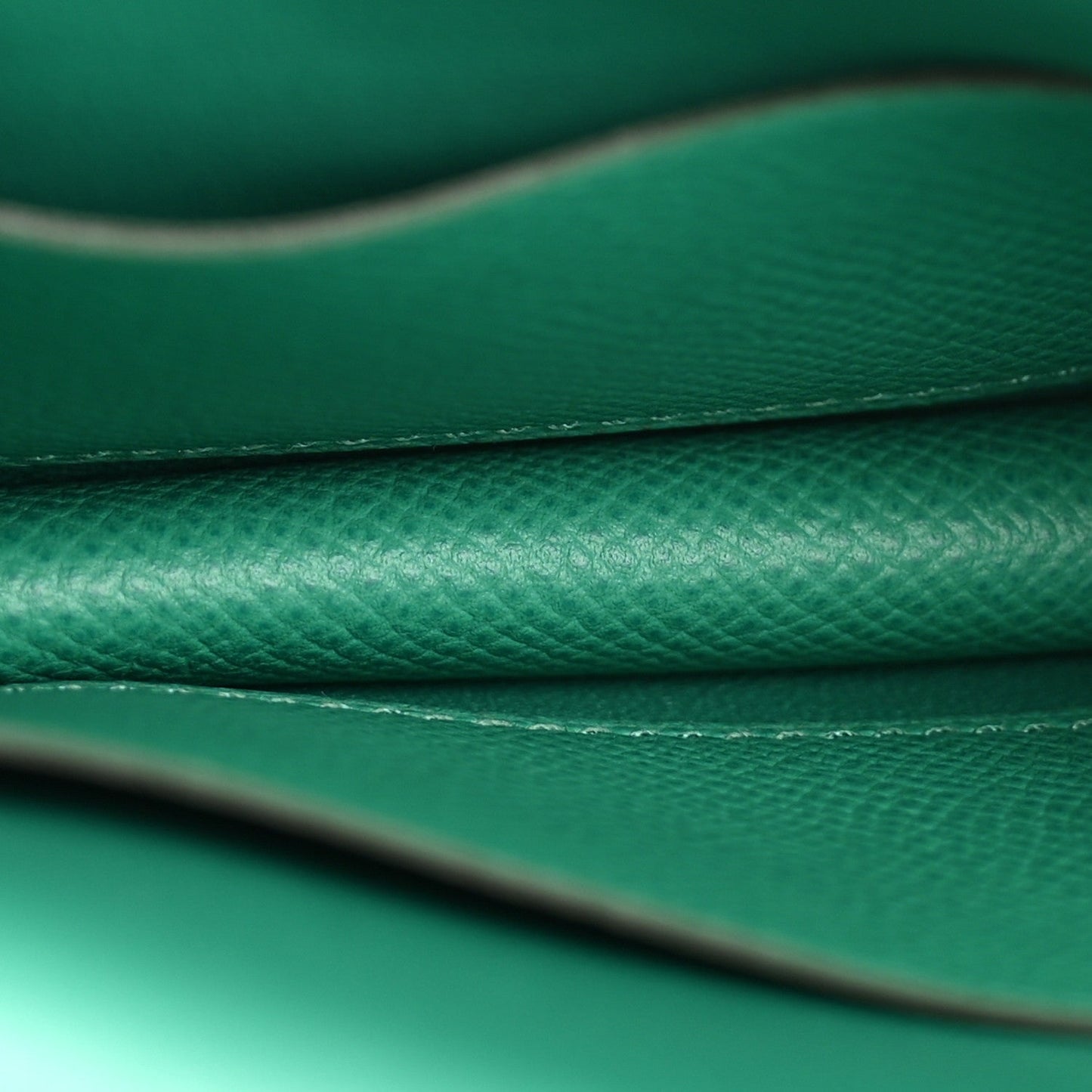 Green leather seam and edge stitching detail with textured grain