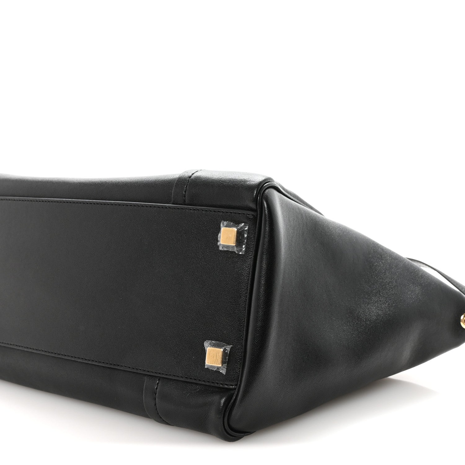 Black leather luggage bag with gold-tone corner hardware and handle.