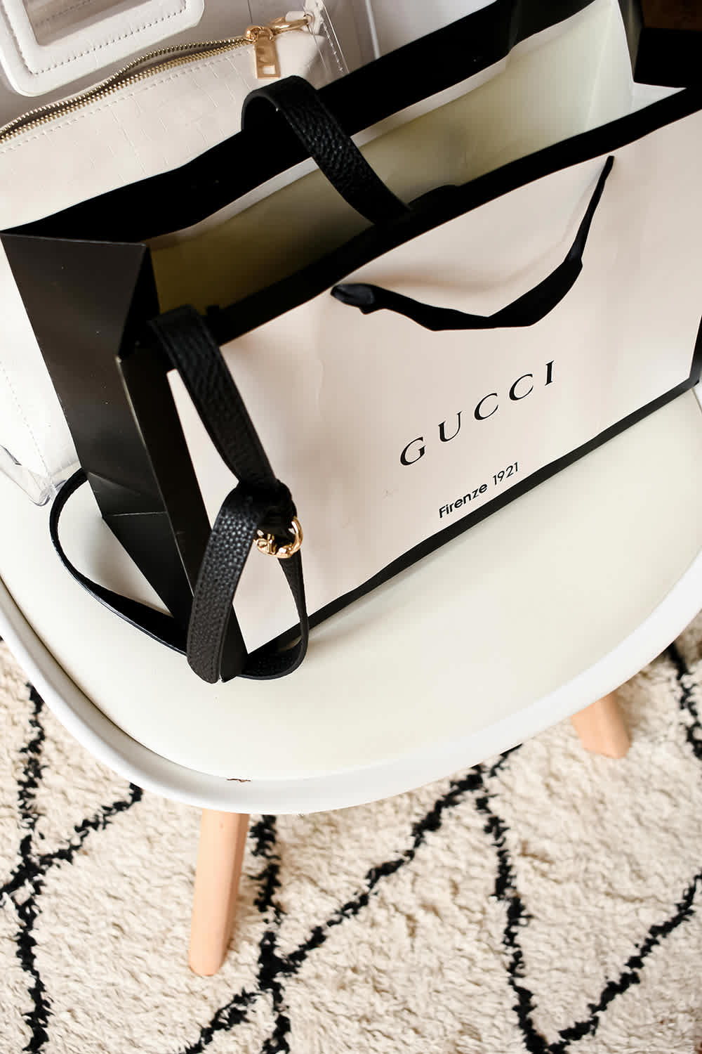 Gucci shopping bag with black handle on a white surface