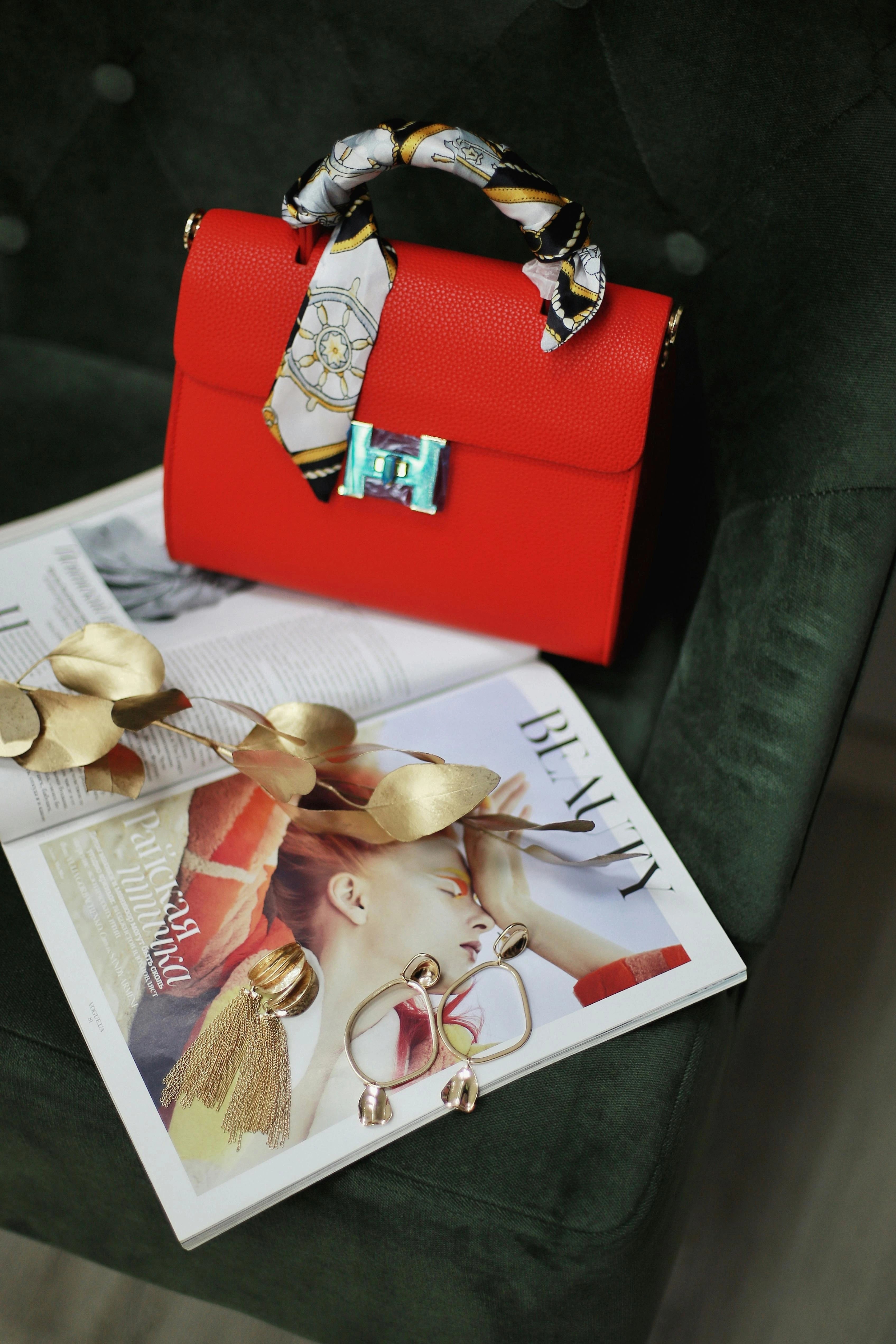 Red handbag with decorative handle on a magazine